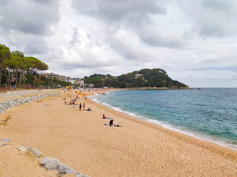 Lloret de mar, Spain - September 30, 2024: People resting at Fenals beach in Lloret de Mar in the Costa Brava, Catalonia, Spain