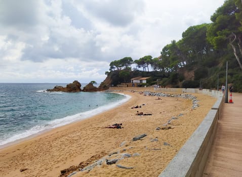 Lloret de mar, Spain - September 30, 2024: People resting at Fenals beach in Lloret de Mar in the Costa Brava, Catalonia, Spain