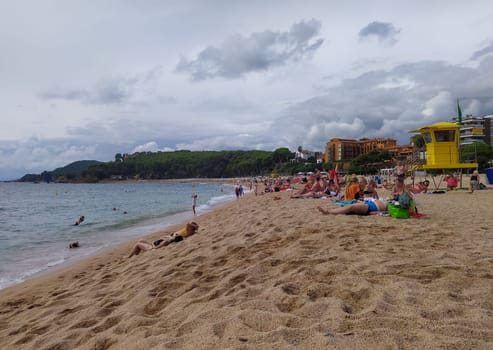 Lloret de mar, Spain - September 30, 2024: People resting at Fenals beach in Lloret de Mar in the Costa Brava, Catalonia, Spain