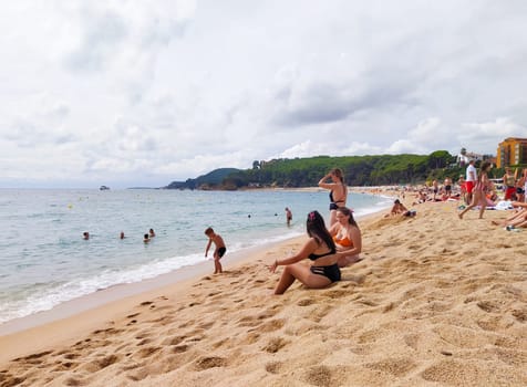 Lloret de mar, Spain - September 30, 2024: People resting at Fenals beach in Lloret de Mar in the Costa Brava, Catalonia, Spain