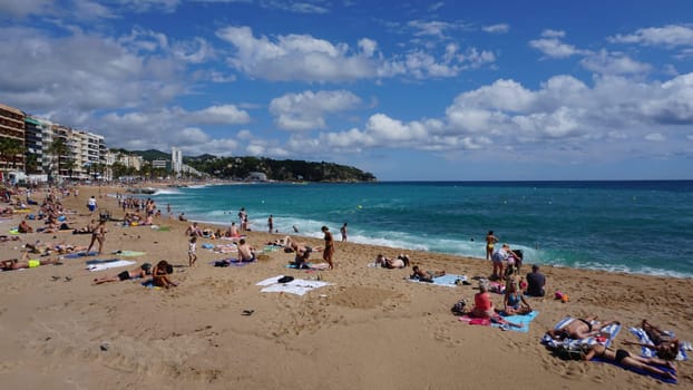 Lloret de mar, Spain - September 30, 2024: People resting at the beach of Lloret De Mar. The beach in Costa Brava of Catalonia at sunny day
