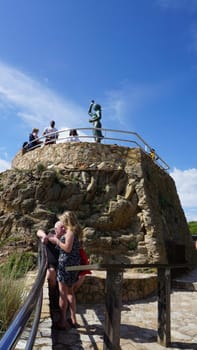Lloret de mar, Spain - September 30, 2024: The people going near sculpture of woman and beach in costa Brava of Catalonia Spain