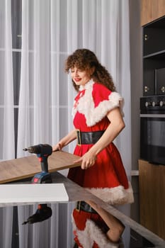 The snow maiden screwed the door hinges to the kitchen cabinet door and lifted it