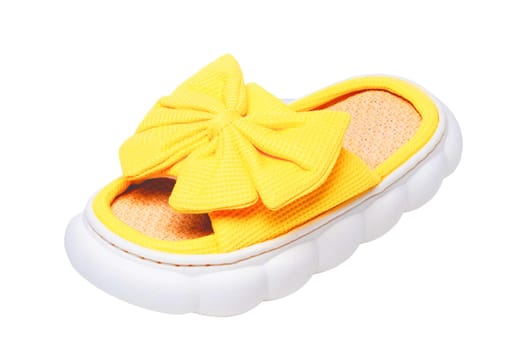 Slippers isolated. Close-up of a single female yellow soft cosy house slipper with a large bow isolated on a white background, Clipping path. Macro. Womans shoes.