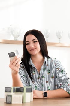 A brunette girl is sitting at a desk in the office looking at the company's products