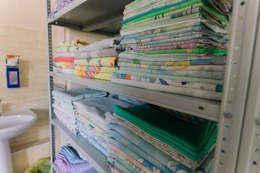 Linens piled neatly on the shelves. There are folded bed sheets, towels, wash clothes