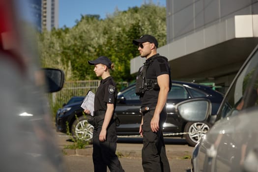 Patrol officers man and woman team wearing uniform watching street providing parking rules violation or other crime
