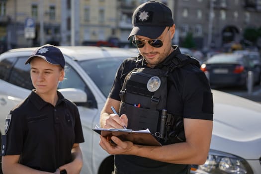 Patrol police team working on city street with parked cars. Police officers at work on street.