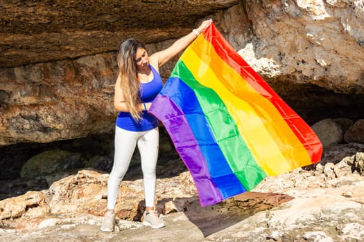 woman, middle aged, outdoors waving pride flag, concept of libertat, equality.