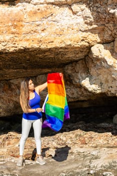 woman, middle aged, outdoors waving pride flag, concept of libertat, equality.