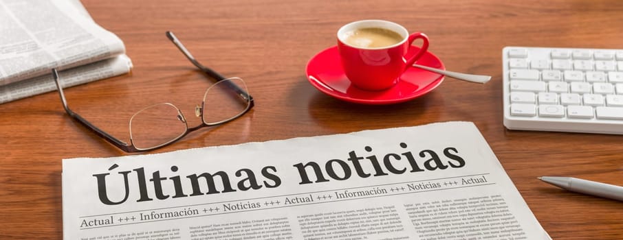 A newspaper on a wooden desk - Breaking News in spanish