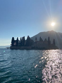 Coastal village nestled between majestic mountains and a serene sea under a clear blue sky. Scene captures the allure of tranquil coastal living and breathtaking natural scenery