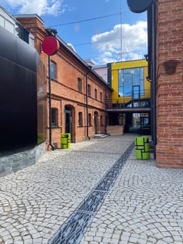 A contemporary street view showcasing a historical building with colorful brick walls, large windows, and sidewalk, in autumn season.