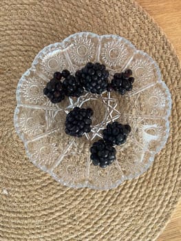 Blackberries on a glass plate top view. Handpicked Blackberries from the Garden