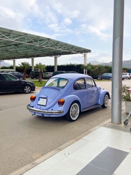 Vintage violet car on the street in summer. Old-fashioned nostalgia and retro style concept.