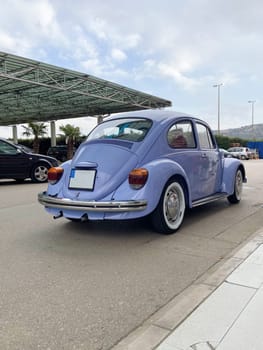 Vintage violet car on the street in summer. Old-fashioned nostalgia and retro style concept.