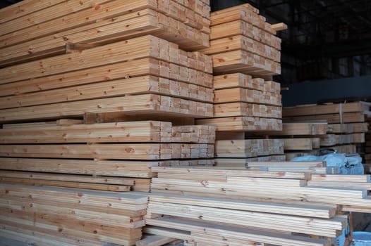 Stacked wooden planks close-up at lumber warehouse. Wood industry concept