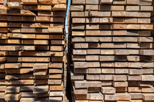 Stacked wooden planks close-up at lumber warehouse. Wood industry concept