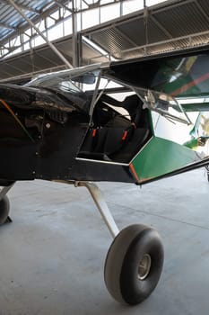 Small private lightweight propeller airplane in hangar, closeup photo