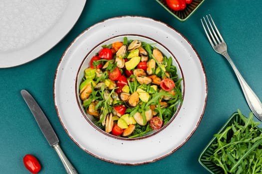 Plate showcasing mussel salad with fresh vegetables.