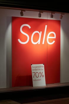 Sale sign in a shop window with the German lettering ausgewählte Artikel bis zu 70 % reduziert. Translation: products reduced by up to 70