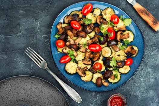 Mushrooms, zucchini and tomatoes baked in the oven on rustic wooden table. Space for text.