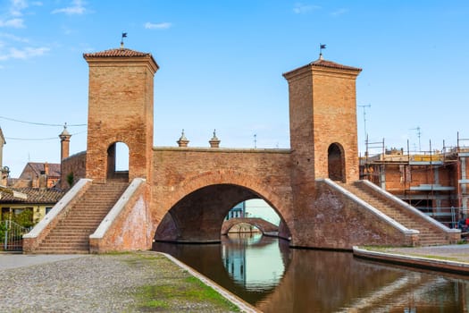 Comacchio, Italy - June 11, 2024: the famous Trepponti bridge, historical symbol of the Italian town. Waterfront view