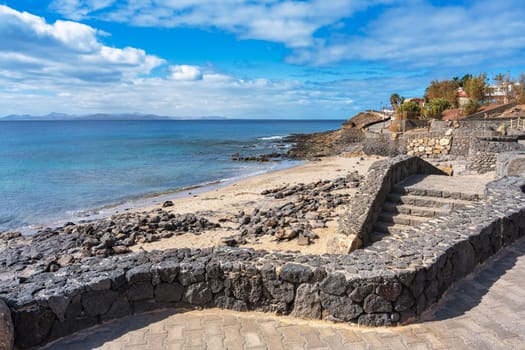 Steps from the promenade down to the beach at Playa Blanca with a view of the Atlantic Ocean on Lanzarote