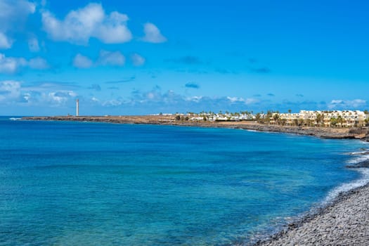 Coastal strip with the promenade at Playa Blanca to the Faro de Punta Pechiguera lighthouse on Lanzarote