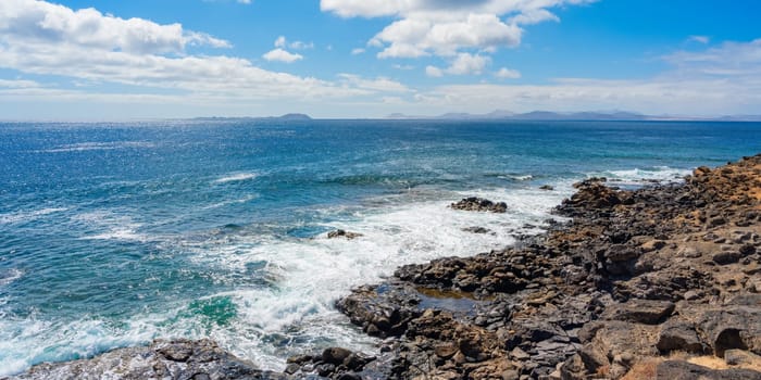 Rocky coastline at Playa Blanca with a view of the beautiful blue Atlantic Ocean on Lanzarote