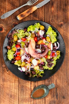 A plate of octopus salad with herbs, potatoes and olives. Free space for your text. Long banner