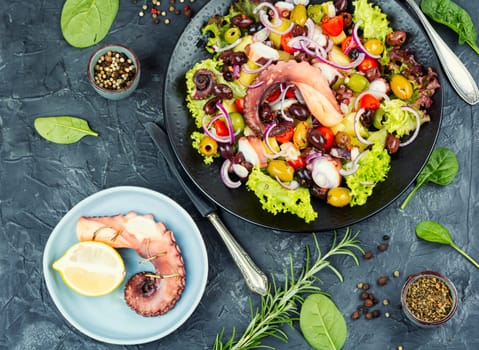 A plate of octopus salad with herbs, potatoes and olives. Free space for your text. Long banner