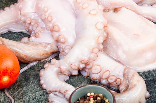 Fresh, whole octopus on table. Photo of a raw octopus, showcasing its intricate tentacles and texture.