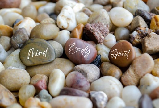 Mind, Body and Spirit text on beach stones. Wellness concept.