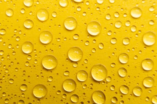 Rain droplets on yellow color background suitable for wallpaper decoration or design.