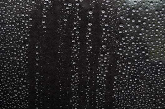 Rain droplets on dark background suitable for wallpaper decoration or design.