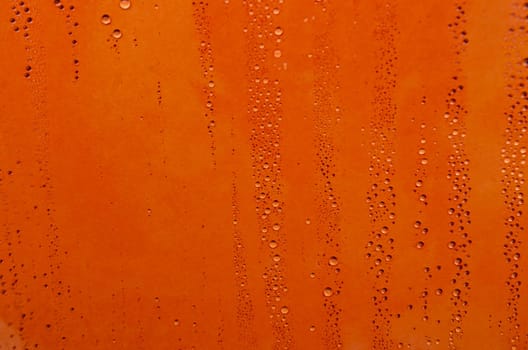 Rain droplets on orange color background suitable for wallpaper decoration or design.