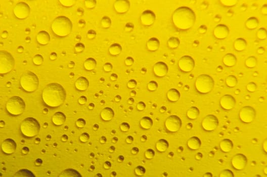 Close up of rain droplets on yellow cover background. Suitable for wallpaper background.