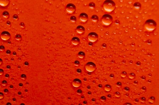 Rain droplets on dark red background suitable for wallpaper decoration or design.