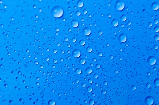 Close up of rain droplets on blue cover background. Suitable for wallpaper background.