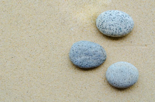 Top view of stones on beach sand with customizable space for text or ideas.