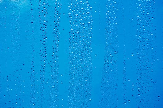 Close up of rain droplets on blue cover background. Suitable for wallpaper background