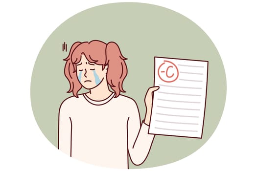 Crying teenage girl depressed because of negative mark on test or exam paper. Unhappy schoolgirl is sad after receiving bad grade from teacher for extracurricular work and needs help of tutor