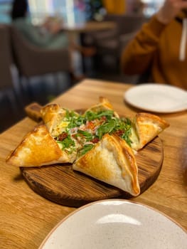 Deliciously presented dish features a unique pastry filled with fresh ingredients, inviting taste and flavor. Culinary creativity on a rustic wooden board, perfect for sharing.