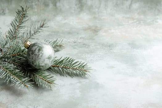 A festive green ornament rests on a pine branch against a muted background capturing the essence of holiday cheer and winters elegance.
