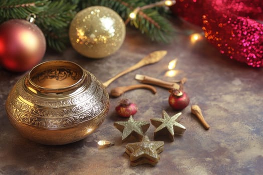 A golden bowl sits among festive ornaments and spices creating a warm holiday atmosphere with twinkling lights in the background.