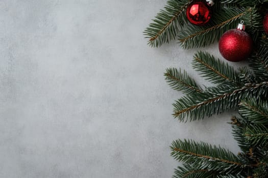 Red and glittering ornaments rest among pine branches creating a festive atmosphere for the winter season.