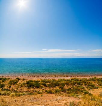large open water surface with far snowcapped mountain range on the horizon at sunny day.
