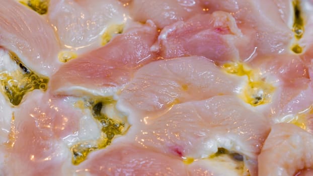 closeup full-frame background of raw chicken breast meat just starting to roast.