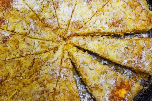 domestic apple pie in a black round cast iron pan sliced into sectors, closeup